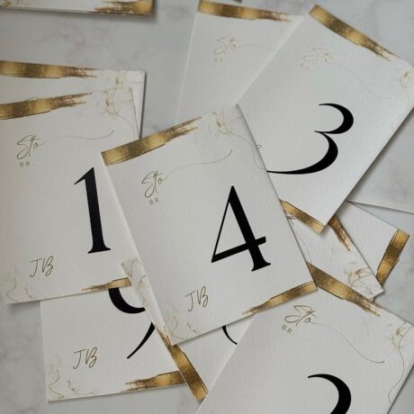 Elegant table number cards in gold and white for wedding or event decor, matching the "Brojevi za st.