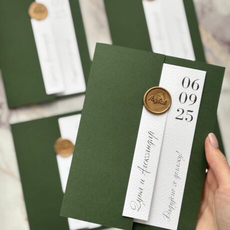 Elegant green wedding invitation with gold wax seal and white label, modern design for special occas.
