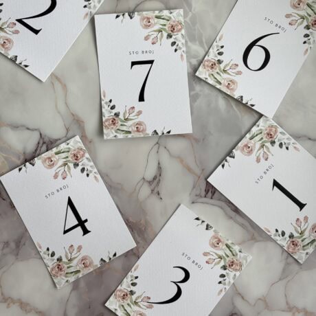 Elegant table number cards with floral accents for wedding or event decor.