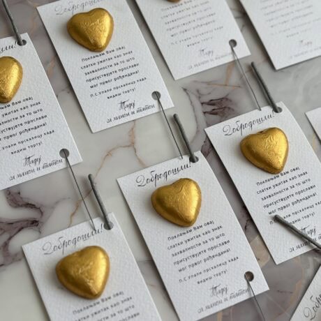 Gold heart-shaped chocolates on personalized greeting cards for birthday celebration.