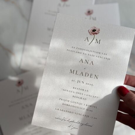 Elegant wedding invitation with pearl finish and floral design.