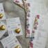 Vibrant floral-themed wedding menu and table cards with gold heart decorations, perfect for elegant event decor.