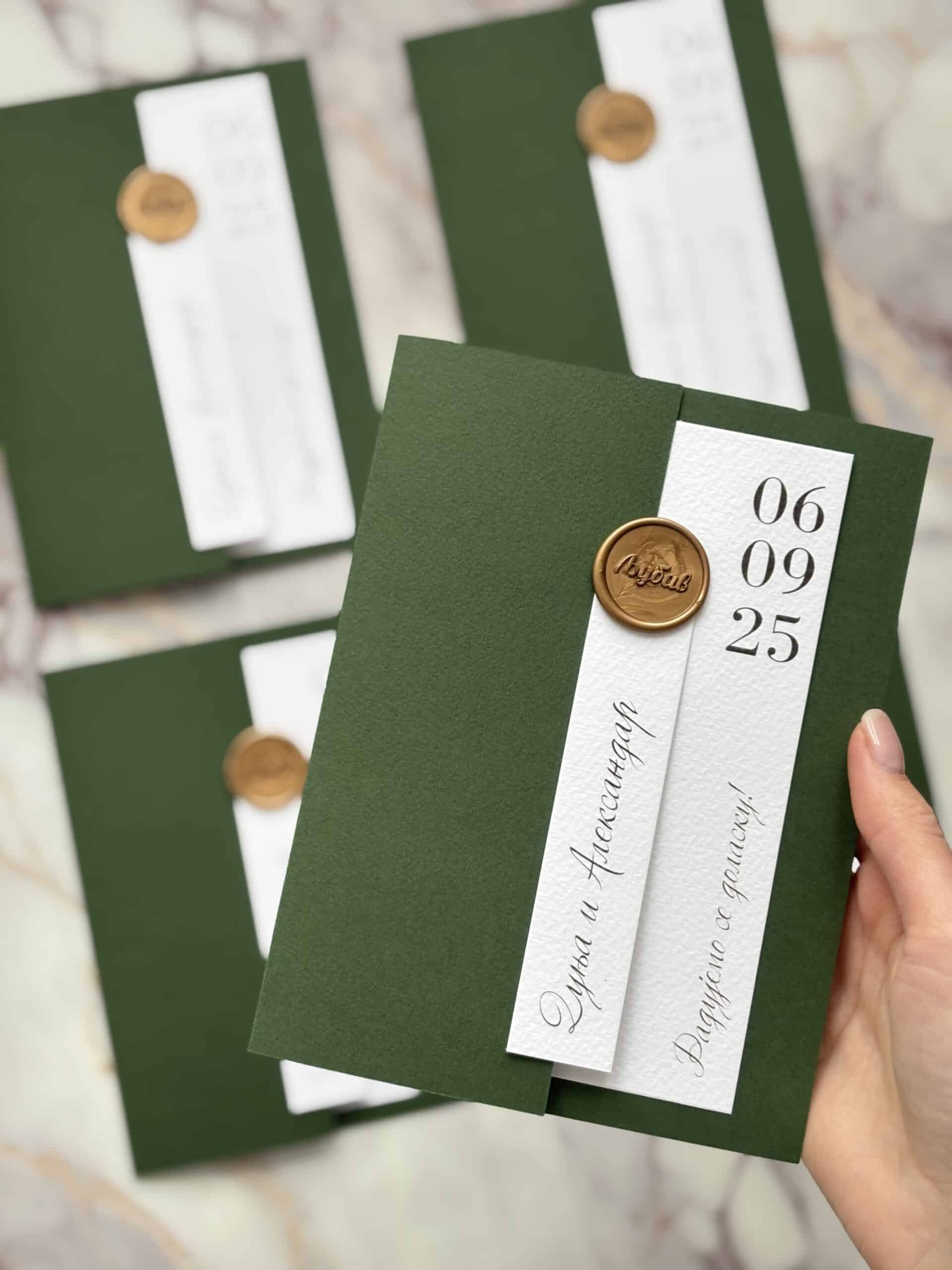 Elegant green wedding invitation with gold wax seal and white label, modern design for special occas.