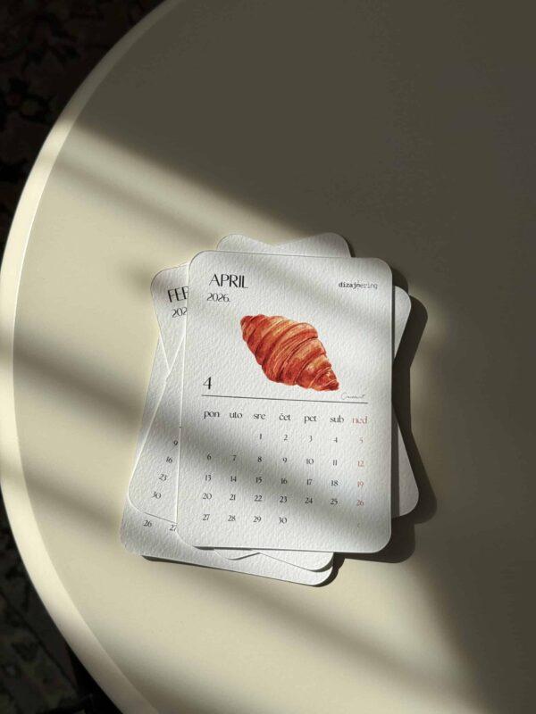 Croissant illustration on April 2026 calendar page, minimalistic design, sunlight and shadow effect, elegant stationery setup.