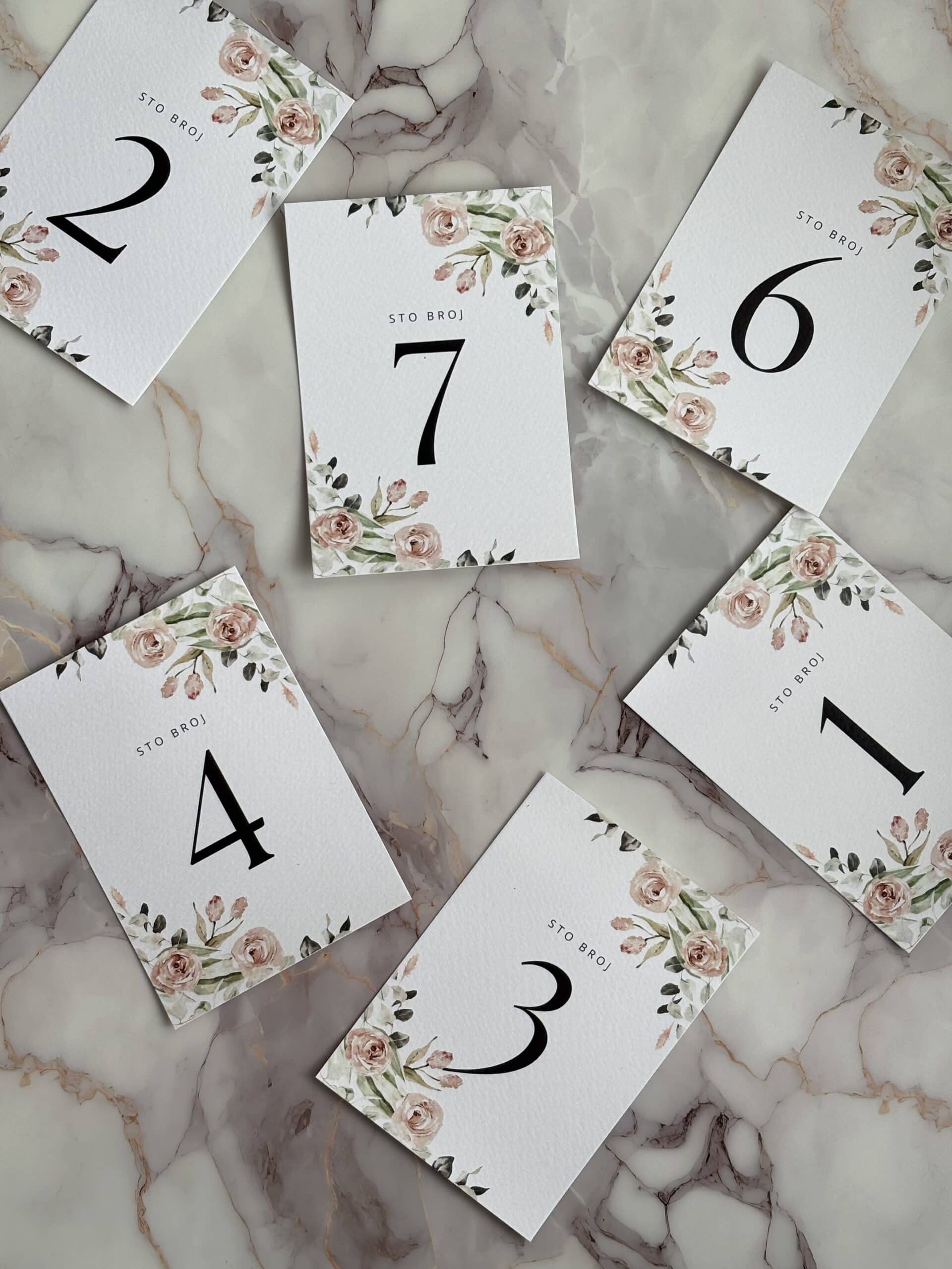 Elegant table number cards with floral accents for wedding or event decor.