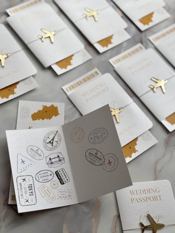 Elegant wedding passport invitation with travel-themed design and gold airplane charm.