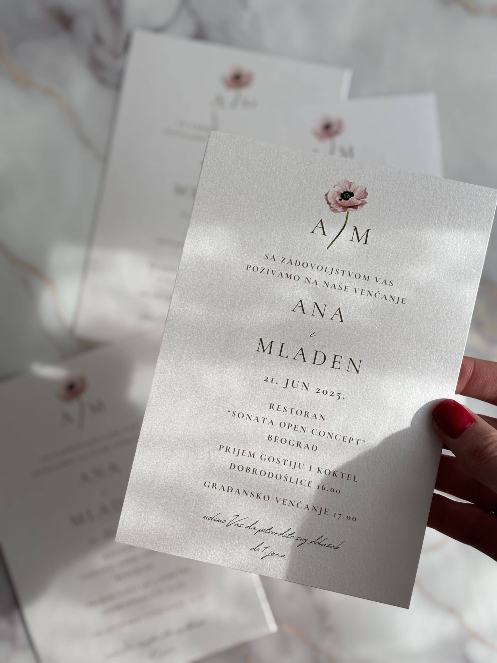 Elegant wedding invitation with pearl finish and floral design.