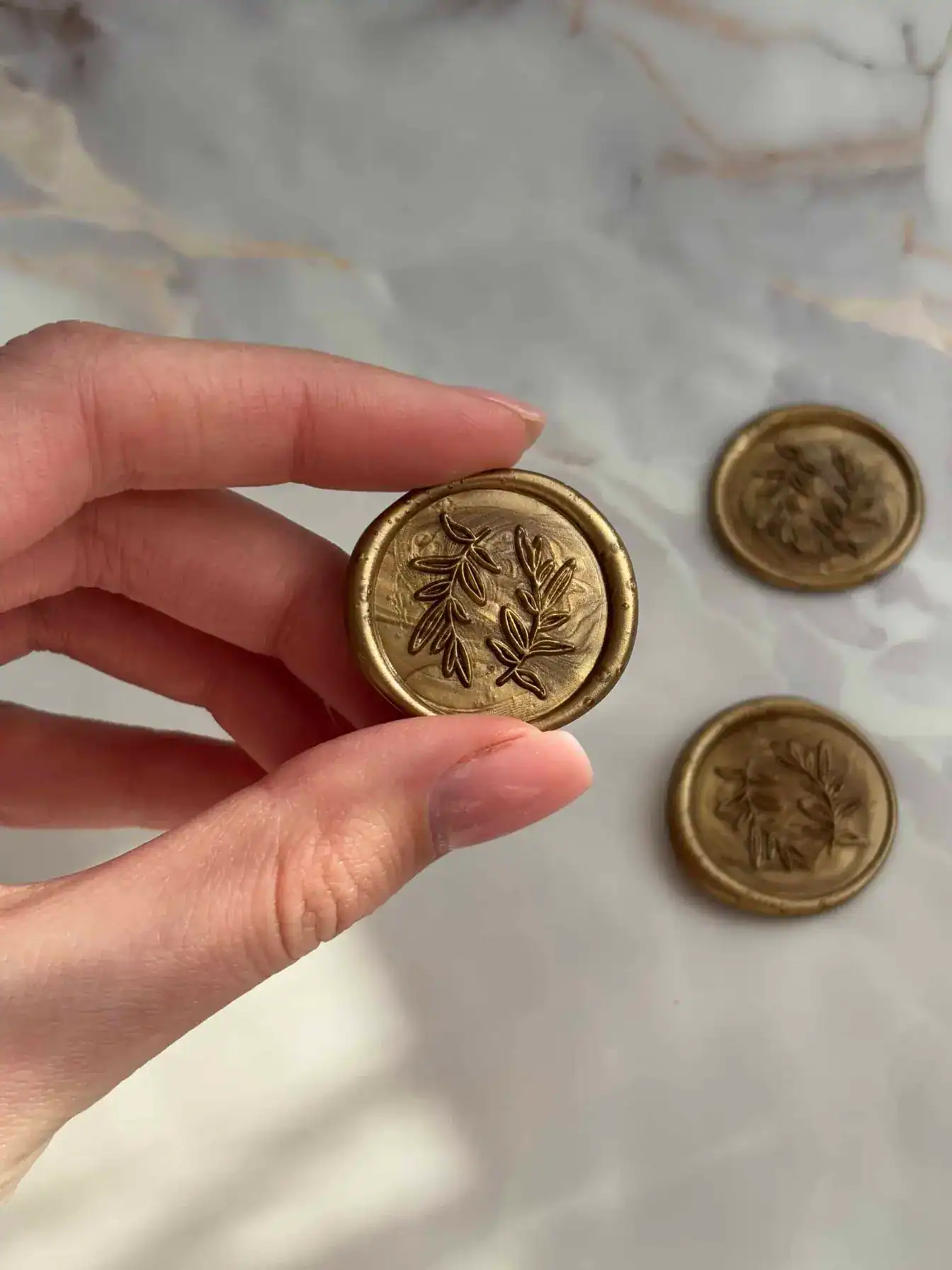Elegant gold wax seal stamp with botanical leaf design for luxury branding and stationery.
