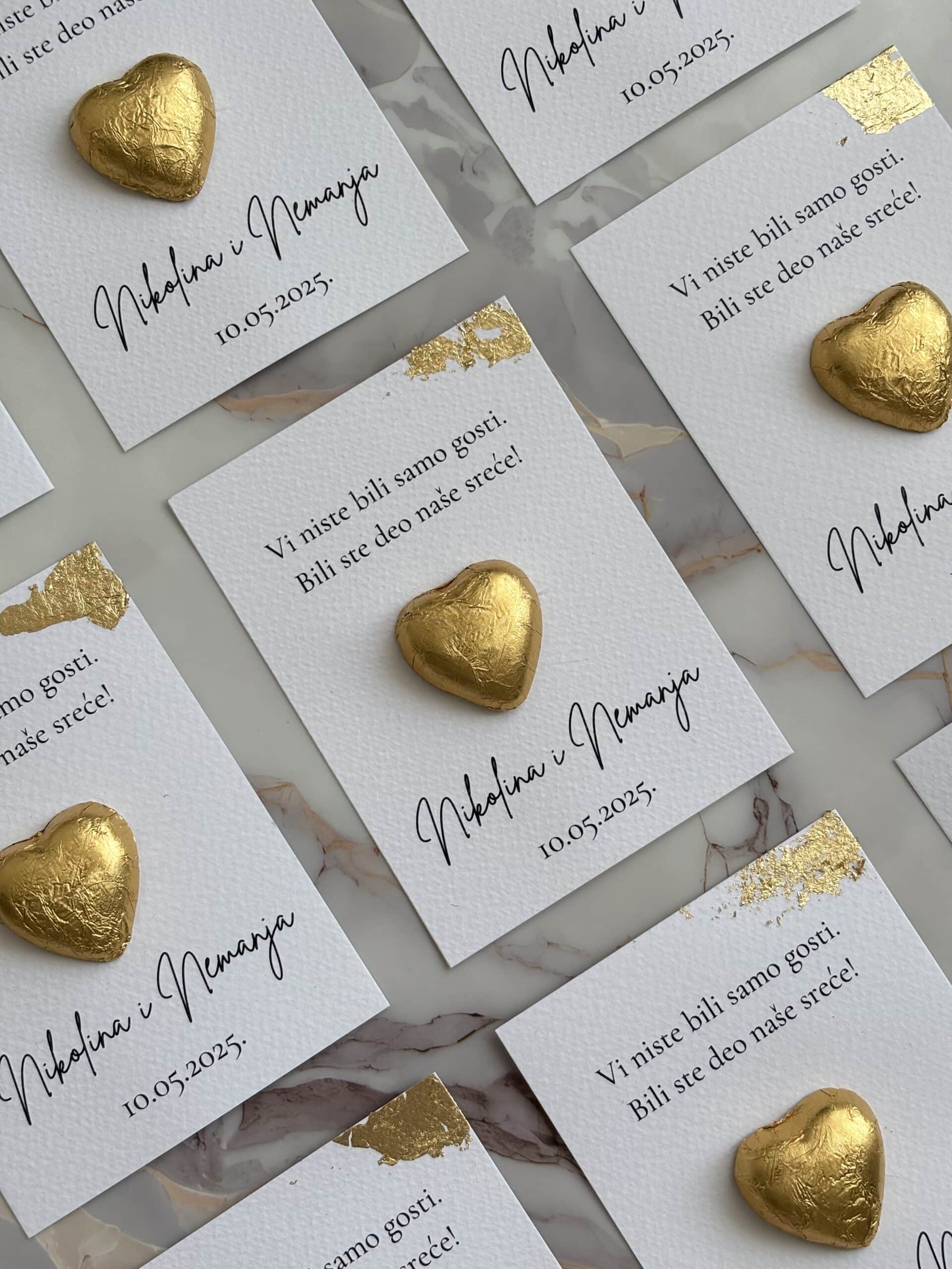Heart-shaped gold foil chocolate on wedding thank you card.